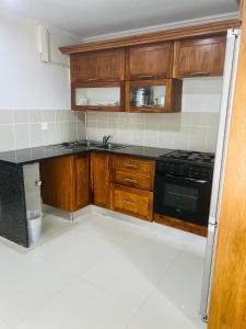a kitchen with wooden cabinets and a black stove at Wild View Resort in Kasane