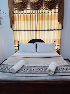 a bed with two pillows and a head board at Ella Bungalow in Ella +17 photos