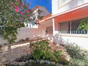 Un patio de una casa con una mesa y sillas. en Residencial El Cortijo by CARLOSFERIEN, en Denia
