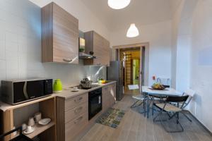 a kitchen with a small table and a microwave at Il Giardino di Tonia - Oplontis Guest House - Bed & Garden - in Torre Annunziata