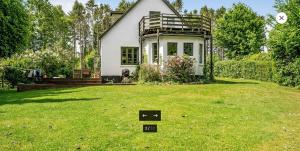 a small house on a lawn with a sign in the yard at Nordic Family Home - Forest & Lake - 29 Min To CPH in Fredensborg