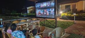 a group of children sitting in chairs watching a screen at The Malshej Mist in Ghātghar