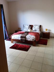 a bedroom with a bed and two rugs on the floor at Casa Mao-Cheia in Arco da Calheta