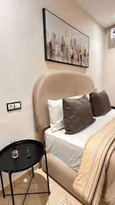 a bedroom with a bed and a table in it at Modern Flat in Khouribga in Khouribga