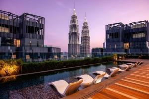 a pool with chairs and the petronas towers at Star Infinity Pool At Klcc in Kuala Lumpur