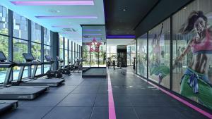 a gym with treadmills and a mural of a woman at Star Infinity Pool At Klcc in Kuala Lumpur