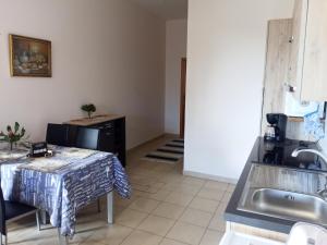 a kitchen with a table and a sink at Casa Mao-Cheia in Arco da Calheta