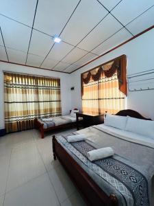 エッラにあるElla Bungalowのベッド2台とソファのある寝室