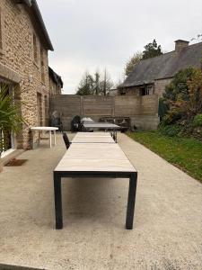 a picnic table in a courtyard with two tables at Le Noisetier in Baguer-Pican