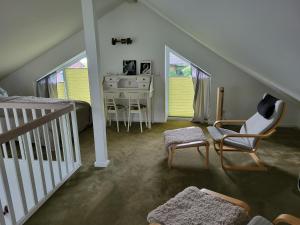 a attic room with a bed and a desk and chairs at Haus Swanhild in Fockbek
