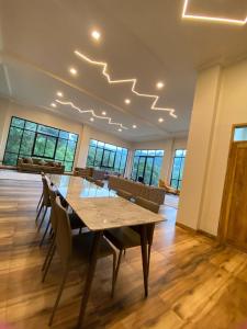 a dining room with a table and chairs and windows at فيلا جولدن فلور بونشاك in Tagalbato +78 photos