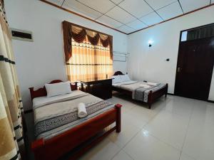 a bedroom with two beds and a window at Ella Bungalow in Ella