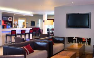 a living room with leather furniture and a flat screen tv at Holiday Inn Express Stoke-On-Trent by IHG in Stoke on Trent