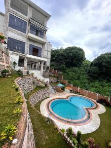a resort with a swimming pool in front of a building at فيلا جولدن فلور بونشاك in Tagalbato