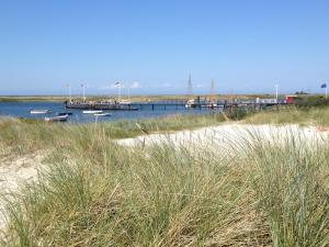a dock with boats in the water next to a beach at Ferienwohnung Marinablick in Wendtorf
