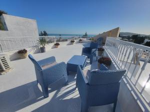 un gruppo di sedie blu sedute su un balcone di Loft marsa cube vue panoramique vue mer a La Marsa