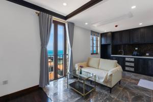 a living room with a couch and a glass table at The Nice Hotel Phu Quoc - Fireworks & Ocean view in Phu Quoc