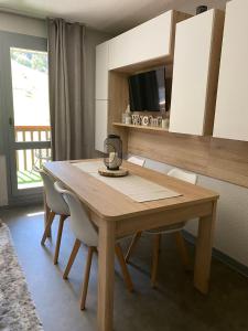 a wooden dining room table with chairs and a mirror at Le Portail 76 in Valmorel