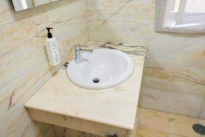 een wastafel in de badkamer met een zeepdispenser op een aanrecht bij Panorama SeaView House in Marinha Grande