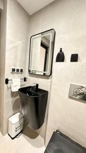 a bathroom with a black sink and a mirror at Modern Flat in Khouribga in Khouribga +23 photos