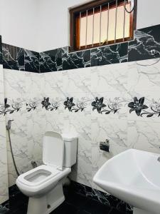 a bathroom with a toilet and a sink at Ella Bungalow in Ella