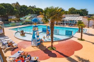 ein Pool in einem Resort mit Leuten, die darin spielen in der Unterkunft Camping Les Peupliers in La Flotte