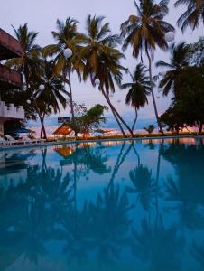 une piscine avec des palmiers en arrière-plan dans l'établissement Treatooo Lake resort, à Batticaloa