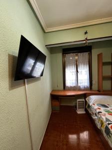 a tv on the wall of a room with a bed at Centrico tu hogar en Bilbao in Barakaldo