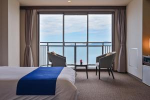 a hotel room with a bed and a large window at Yunoko Umi To Yuyake in Minamata +104 photos