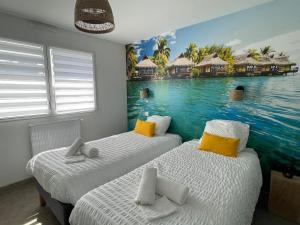 two beds in a room with a mural of a resort at Villa Noz Vat 4 étoiles avec SPA in Plouescat +47 photos