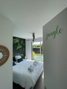 a bedroom with a large bed with towels on it at Villa Noz Vat 4 étoiles avec SPA in Plouescat