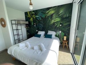 a bedroom with a large white bed with blue pillows at Villa Noz Vat 4 étoiles avec SPA in Plouescat