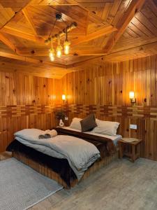a bedroom with two beds in a wooden room at Avasaa Café and Stay in Jibhi