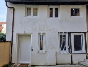 a white house with windows and a door at Duplex avec baignoire balnéo à 10 min de Strasbourg in Schiltigheim