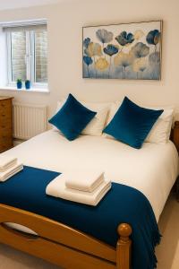 a bedroom with a bed with blue pillows at The Little Nest in Colchester in Colchester