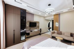 a bedroom with a bed and a tv and a couch at Residence Hotel Spa in Taraz