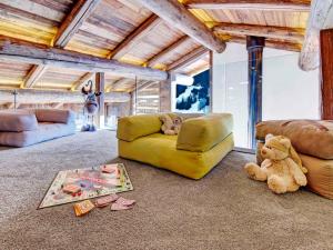 - un salon avec un canapé et un ours en peluche dans l'établissement Chalet 5★, 9 pers., spa, cinéma, 4 chambres, navette 300 m - FR-1-304-310, à La Clusaz