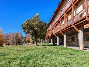 a large building with a grass field next to it at Dúplex rústico familiar- Amplitud y vistas espectaculares - Cuc 2 in Pla de l'Ermita