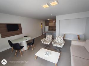 a living room with a couch and a table and chairs at Recife Mar Flats Hotel in Recife
