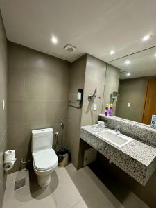 a bathroom with a toilet and a sink and a mirror at Recife Mar Flats Hotel in Recife +85 photos