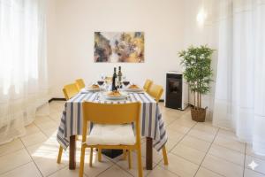 een eetkamer met een tafel met gele stoelen bij Perla d'aMare in San Lorenzo al Mare