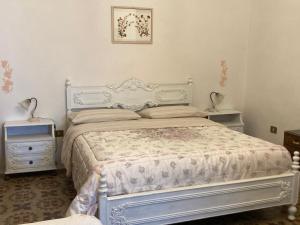 a bedroom with a white bed and two night stands at La Maison Di Monica in Polignano a Mare