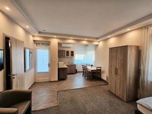 a living room with a table and a kitchen at Mediterrán Villa Kecskemét in Kecskemét