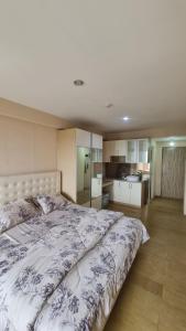 a bedroom with a large bed and a kitchen at Jendela360 in Jomblang