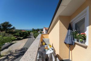 einen Tisch auf dem Balkon eines Gebäudes mit Sonnenschirm in der Unterkunft Studio für 2 Personen   1 Kind ca 40 qm in Šilo, Kvarner Bucht Krk - b58893 in Šilo + 19 Fotos