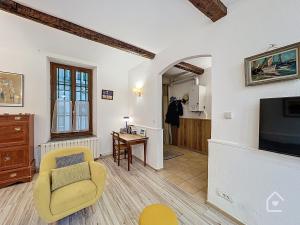 un salon avec une télévision et une chaise dans l'établissement Easy House - Climatisation - 1 min Vieux Port, à La Ciotat