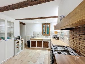 une cuisine avec des murs blancs et un mur de briques dans l'établissement Easy House - Climatisation - 1 min Vieux Port, à La Ciotat