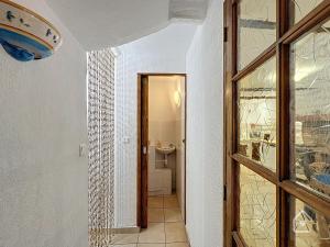 un couloir avec une porte menant à une salle de bains. dans l'établissement Easy House - Climatisation - 1 min Vieux Port, à La Ciotat