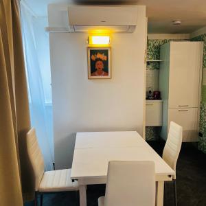 Casa Francis في ماتيرا: غرفة طعام مع طاولة بيضاء وكراسي