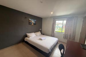a small bedroom with a bed and a window at Tiong Nam Hotel Near Pasir Gudang in Pasir Gudang